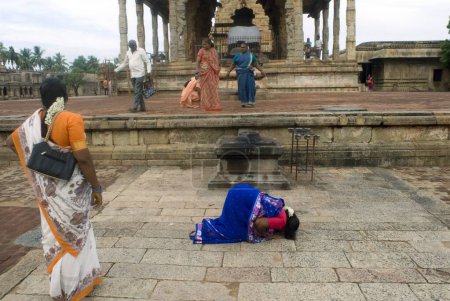 Foto de Devoto inclinándose en el templo de Brihadeshwara también llamado templo grande construido en el décimo siglo AD Por Raja Raja Chola Dedicado al señor Shiva en Thanjavur, Tamil Nadu, la India - Imagen libre de derechos