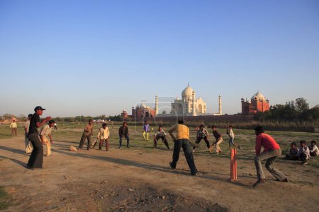 Photo for Children playing cricket at Taj Mahal Seventh Wonders of World on south bank of Yamuna river , Agra , Uttar Pradesh , India UNESCO World Heritage Site - Royalty Free Image