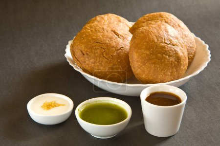Indischer Snack gebraten shahi khasta kachori chaat in Schüssel mit Joghurt grünem Koriander und Tamarindenchutney auf schwarzem Hintergrund 23-April-2010