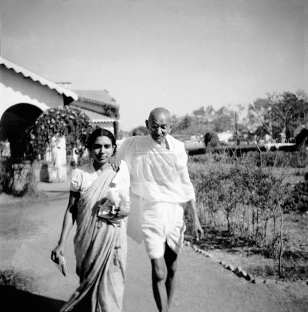 Téléchargez les photos : Sushila Nayar et Mahatma Gandhi marchant à l'Ashram de Rashtriyashala, Rajkot, juste après avoir pris un bain deux heures avant de commencer rapidement, 1939, Inde - en image libre de droit