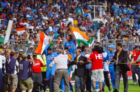Téléchargez les photos : Le batteur indien Sachin Tendulkar est porté sur les épaules par ses coéquipiers alors qu'il agite le tricolore après que l'Inde a vaincu le Sri Lanka lors de la finale de la Coupe du monde de cricket 2011 de l'ICC jouée au stade Wankhede à Mumbai en Inde le 2 avril 2011 - en image libre de droit