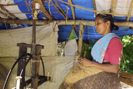 Foto de Keralite mujer haciendo cuerda de coco en casa de campo, método tradicional, Kerala, India - Imagen libre de derechos