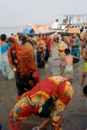 Foto de Mujer bengalesa bañándose en Babu Ghat en la celebración de Kartik Purnima, Kolkata, Bengala Occidental, India - Imagen libre de derechos