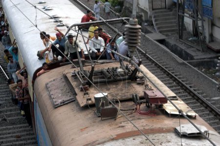 Téléchargez les photos : Garçons qui font la navette assis sur le toit des trains locaux - en image libre de droit