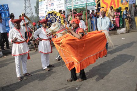 Foto de Kachi Ghodi, Hombres de pie en caballo maniquí y la realización de danza Ranjasthani usando traje de maratha durante la procesión religiosa - Imagen libre de derechos