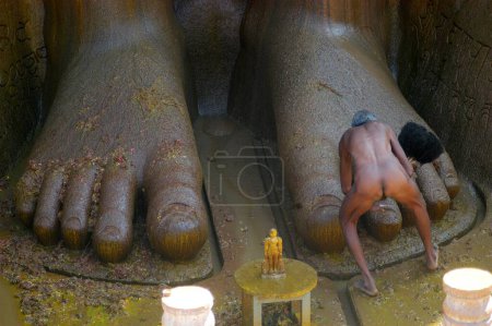 Foto de Desnudo Jain sadhu tocar pies de 57 pies de altura estatua del señor Bahubali conocido como Gomateshwara en Mahamastakabhisheka celebración en Shravanabelagola en el distrito de Hassan de Karnataka, India - Imagen libre de derechos