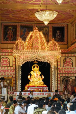 Photo for Idol of Lord Ganesh with richly illuminated decoration of Dagdu Seth Halwai Mandal Ganapati festival of 2008 at Pune ; Maharashtra ; India - Royalty Free Image
