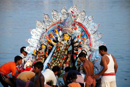 Téléchargez les photos : Des dévots plongeant le modèle Durga dans la rivière - en image libre de droit