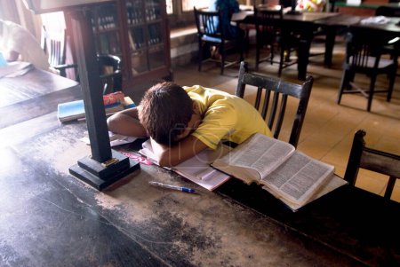Foto de Un estudiante durmiendo en una biblioteca de la ciudad, Bombay ahora Mumbai, Maharashtra, India - Imagen libre de derechos