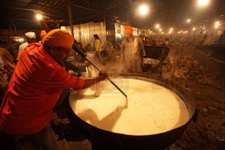 Téléchargez les photos : Kheer en préparation par un karsevak à l'intérieur d'une cuisine communautaire à Sachkhand Saheb Gurudwara, 300e année de consécration du Guru-Granth Sahib à Nanded, Maharashtra, Inde 30-octobre-2008 - en image libre de droit
