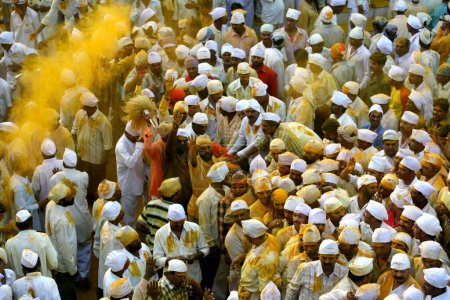 Foto de Devotos frotando polvo de cúrcuma al Palkhi del señor Khandoba durante las celebraciones del Dasshera en el templo famoso de Jejuri, pune, Maharashtra, India - Imagen libre de derechos
