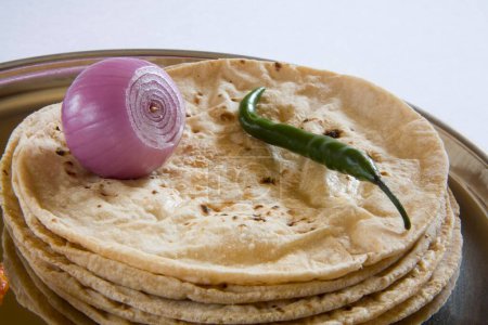 Téléchargez les photos : Cuisine indienne roti chapatti pain quotidien à base de farine de blé atta avec piment vert mangue cornichons achar et oignon servi dans une assiette, Inde - en image libre de droit