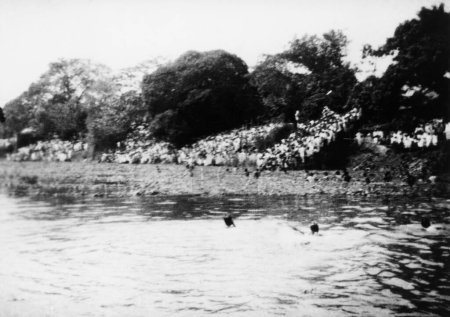 Téléchargez les photos : Foules debout près d'une rivière où les cendres du Mahatma Gandhis se dissolvent, Dacca, février 1948 - en image libre de droit