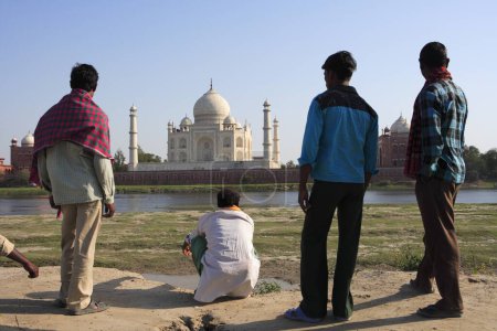 Photo for Local villagers viewing at Taj Mahal Seventh Wonders of World on south bank of Yamuna river , Agra , Uttar Pradesh , India UNESCO World Heritage Site - Royalty Free Image