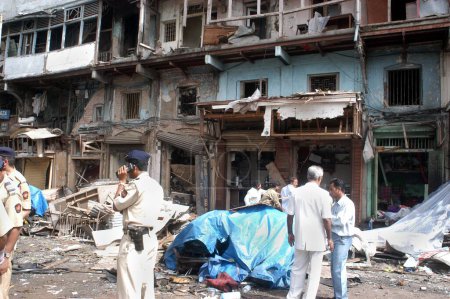 Foto de Policías inspeccionan sitio de explosión de bomba en Zaveri Bazaar en el área ocupada de Kalbadevi, Bombay Mumbai, Maharashtra, India El 26 de agosto de 2003 - Imagen libre de derechos