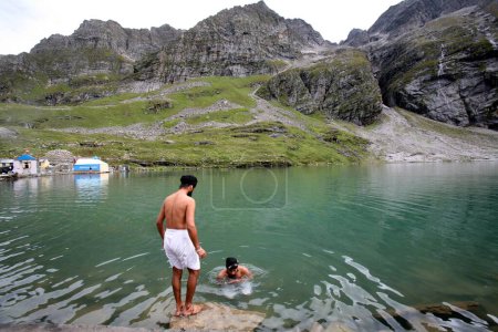 Photo for Sikh devotees taking a dip at the Hemkund Lake, Sikhs shrine Shri Hemkund Sahib situated (4320 meters high) at Govind ghat which is the gateway to the Bhvundar or Lakshman Ganga valley, Uttaranchal, India - Royalty Free Image