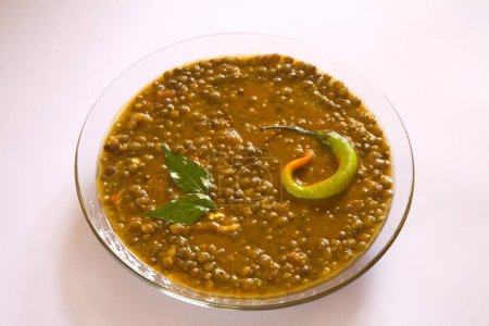 Foto de Indian masoor dal  red gram lentil soup garnish with curry leaves and chilli in glass bowl on white background - Imagen libre de derechos