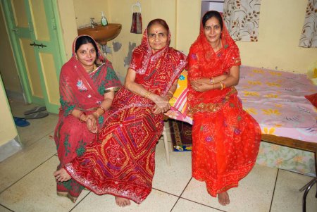 Foto de Madre, en, ley flanqueada por dos hijas, en, la ley en un hogar, Jodhpur, Rajastán, India - Imagen libre de derechos