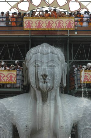 Photo for Pouring milk on head of 58.8 feet monolithic Statue of jain saint Gomateshwara Lord Bahubali in mahamastakabhisheka head anointing ceremony, Vindhyagiri hill; Sravanabelagola, Karnataka, India - Royalty Free Image