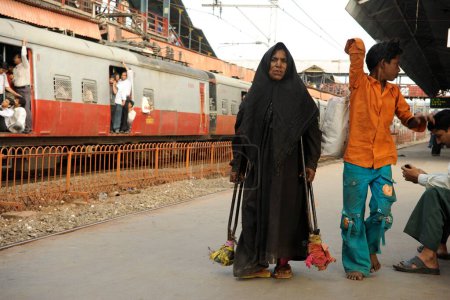 Foto de Dama musulmana discapacitada con muletas en la plataforma, India - Imagen libre de derechos