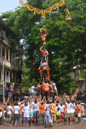 Photo for Human pyramid trying to break dahi handi on janmashtami festival at dadar, Bombay, Mumbai, Maharashtra, India - Royalty Free Image