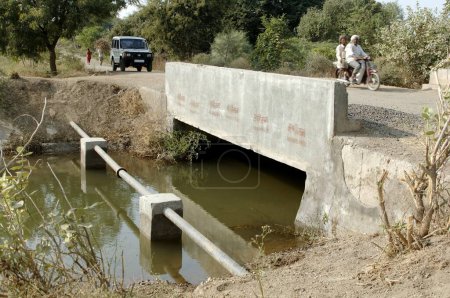 Foto de Tubería de agua siguiente puente y sobre el agua, Akola, Akot, Maharashtra, India - Imagen libre de derechos