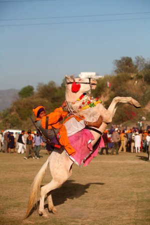 Foto de Nihang o Sikh guerrero con rifle a caballo durante Hola Mohalla celebración en Anandpur sahib en el distrito de Rupnagar, Punjab, India - Imagen libre de derechos