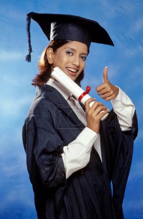 young girl holding graduation degree ; india
