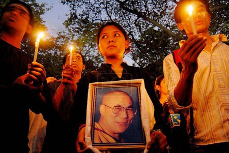 Photo for Tibetans holding photograph of Dalai Lama and candles protesting against Chinese crackdown in Tibet, Bombay Mumbai, Maharashtra, India - Royalty Free Image