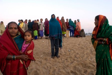 Téléchargez les photos : Les gens se rassemblent tôt le matin pour entrevoir le premier rayon de soleil à frapper sur la terre en Inde à Chandrabhaga près du temple Konarak, Konarak, Orissa, Inde - en image libre de droit