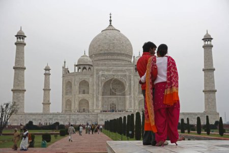 Téléchargez les photos : Jeune couple au Taj Mahal Septième merveilles du monde sur la rive sud de la rivière Yamuna, Agra, Uttar Pradesh, Inde Site du patrimoine mondial de l'UNESCO - en image libre de droit