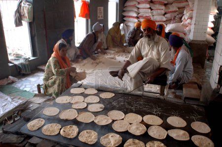Téléchargez les photos : Langar, cuisine communautaire, libre food-guru ka langar, la cuisine des gourous introduite par le gourou Amar Das pour faire fondre les barrières des castes et fournir de la nourriture gratuite à des milliers de pèlerins par le biais du service volontaire, Golden temple, Amritsar, Punjab, Inde - en image libre de droit