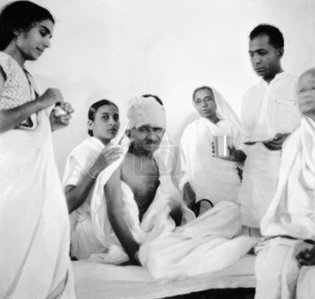 Téléchargez les photos : Mahatma Gandhi après avoir rompu son jeûne à l'Ashram de Rashtriyashala, Rajkot, 1939, Sushila Nayar, Vijyabehn Pancholi épouse de Manubhai Pancholi, Brijkrishan Chandiwalla, Manibehn Patel, Inde - en image libre de droit