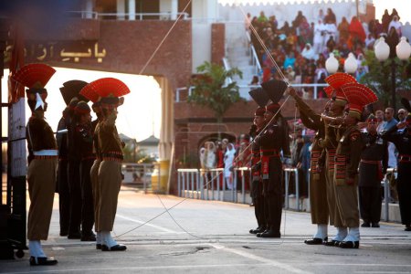 Téléchargez les photos : Des soldats des forces de sécurité frontalières indiennes et leur homologue pakistanais défilent avant de commencer la cérémonie de changement de garde à la frontière de Wagah, Amritsar, Punjab, Inde - en image libre de droit