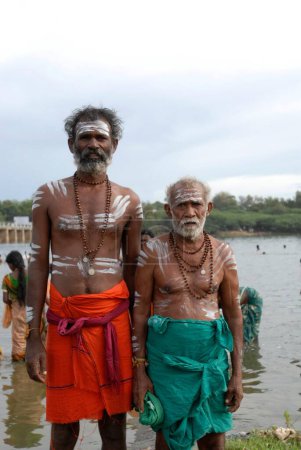 Téléchargez les photos : Pèlerins décorés de cendres sacrées après le bain dans la rivière Tamiravaruni, Tiruchendur, Tamil Nadu, Inde - en image libre de droit