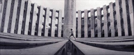 Téléchargez les photos : Jantar Mantar ; New Delhi ; Inde Panaromic View Of A Boy Jumping On The Stone Sun Dial ; Avec les colonnes et la colonne centrale en arrière-plan - en image libre de droit