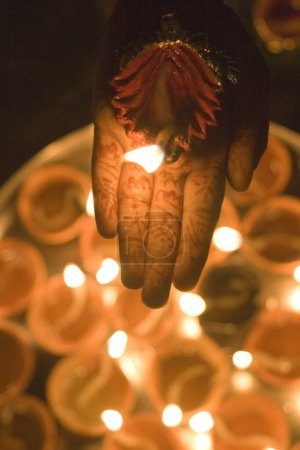 Woman holding diya dip dipak oil lamp on hand , Mehandi Heena pattern , Diwali deepawali festival , India