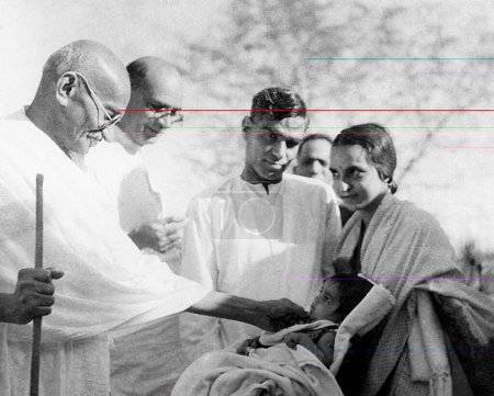 Téléchargez les photos : Mahatma Gandhi, Mahadev Desai, Shri Girdharilal jouant avec l'enfant Krupalis et d'autres à l'Ashram de Sevagram, 1939 - en image libre de droit