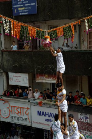 Téléchargez les photos : Govinda pyramide humaine essayant de briser Dahi Handi sur Janmashtmi - en image libre de droit