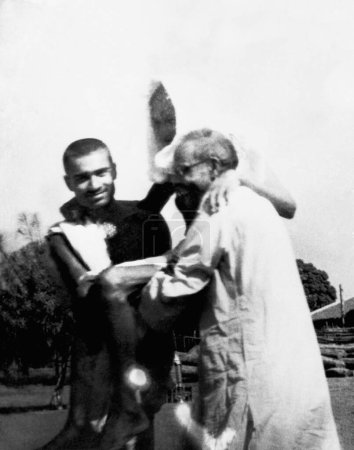 Foto de Kanu Gandhi y el Dr. Das llevando a Mahatma Gandhi, quien está en el tercer día de su ayuno en el Ashram Sevagram, 1941 - Imagen libre de derechos