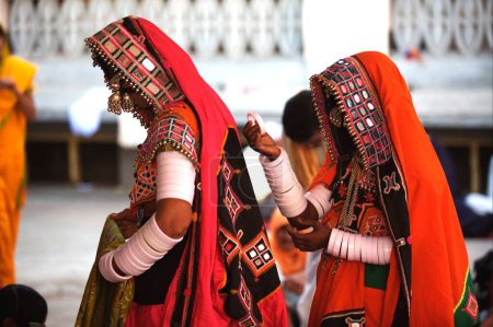 Foto de Mujeres nómadas vestidas con su traje colorido tradicional sentadas fuera del Saheb Gurudwara de Sachkhand en Nanded, Maharashtra, India - Imagen libre de derechos