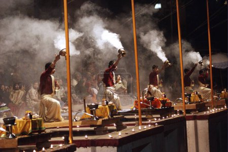 Téléchargez les photos : Les jeunes prêtres interprètent Ganga Aarti à Dasasaswamedh Ghat qui commence juste après le coucher du soleil à Varanasi, ou banaras, (également connu sous le nom de Kashi), Uttar Pradesh, Inde - en image libre de droit