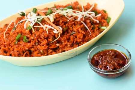 Schezwan gebratener Reis mit Schezwan-Sauce, gebratener Reis aus China, garniert mit Frühlingszwiebeln und Kohl.
