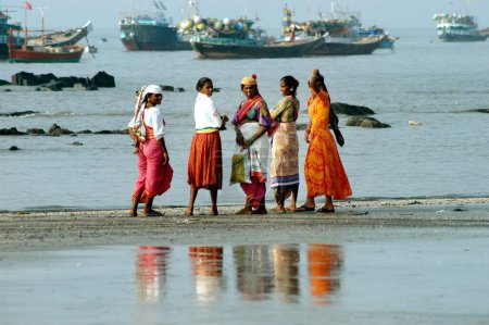 Foto de Pescadoras indias del sur de Asia esperan que el pescado sea transportado desde botes en Uttan Beach; cerca de Bombay ahora Mumbai; Maharashtra; India - Imagen libre de derechos