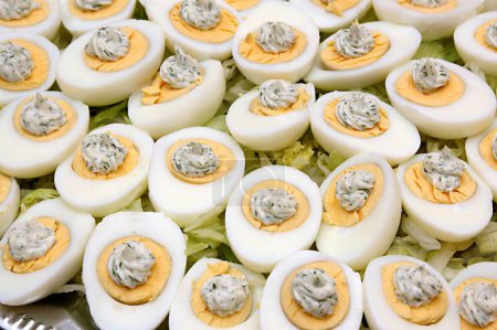 Lebensmittel, gekochte Eier mit Mayonnaise und Petersilie, halb geschnittene gekochte Eier in Stahlplatte