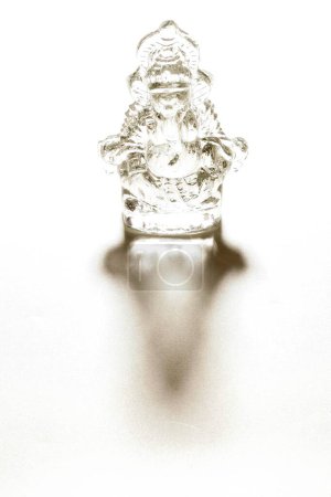 Foto de Ídolo de cristal de Señor Ganesh elefante cabeza dios con sombra sobre fondo blanco; Pune; Maharashtra; India - Imagen libre de derechos