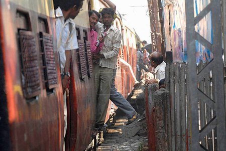 Photo for Commuter dangerously catches local train in Bombay Mumbai ; Maharashtra ; India - Royalty Free Image