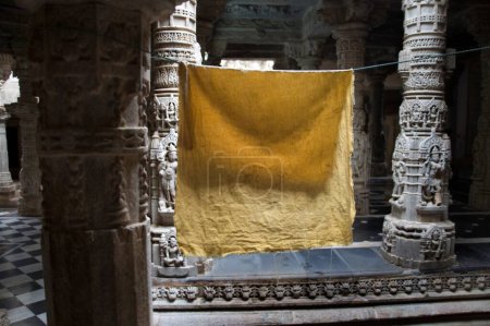 Téléchargez les photos : Tissu jaune sur corde séchant à des piliers sculptés et galerie autour de 2000 ans monument antique ; Temple Adinath Jain ; patrimoine village Dilwara ; Udaipur ; Rajasthan ; Inde - en image libre de droit