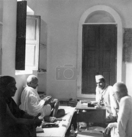 Foto de Mahatma Gandhi en una reunión con Sushila Nayar, Rajendra Prasad y Abdul Kalam Maulana Azad en la Colonia Bhangi en Delhi, 1946, India - Imagen libre de derechos