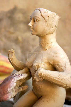 Photo for Sculptor making goddess Durga sculpture using of clay   for Durga Pooja preparation ; Rajkot ; Gujarat; India - Royalty Free Image